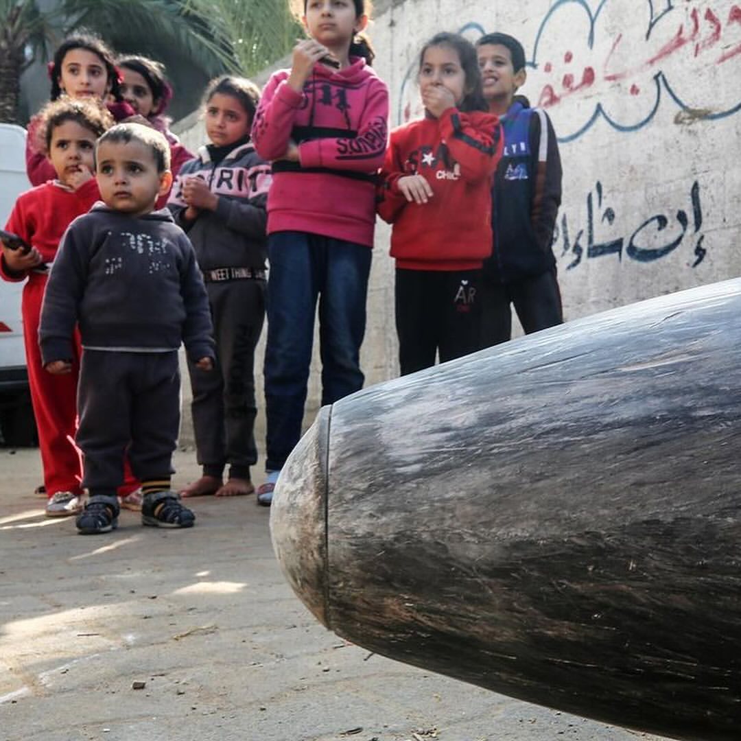 palestinian-children-stand-next-to-an-unexploded-bomb-dropped-by-an-israeli-f-16-warplane-on-deir-al-balah,-central-gaza…